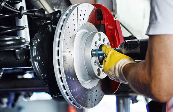 Full size photo of automotive mechanic replacing brake rotor